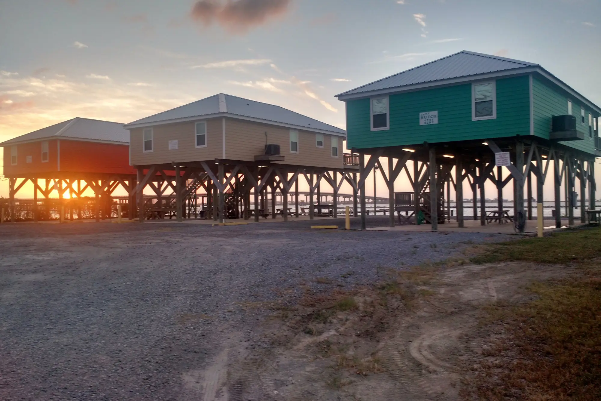 A row of houses raised high on wooden pilings at dusk on Grand Isle, Louisiana